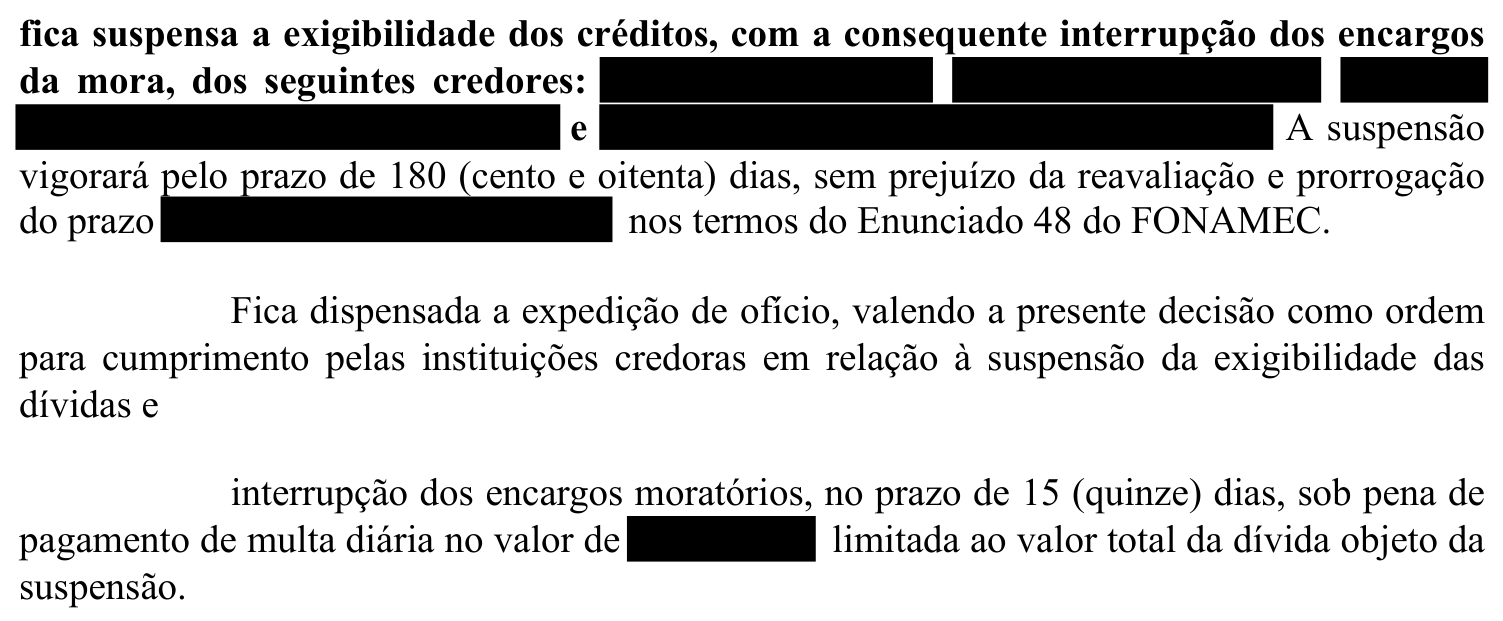 Recorte original de decisão provisória que interrompe encargos de mora e suspende a exigibilidade dos créditos, com dados identificadores ocultados